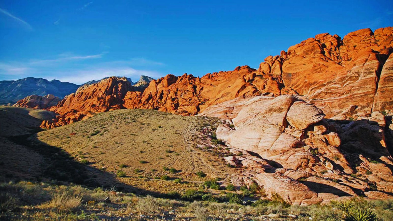 Photograph of Red Rock Canyon, showcasing vibrant red rock formations and desert landscape by Jimmy Kirk.
