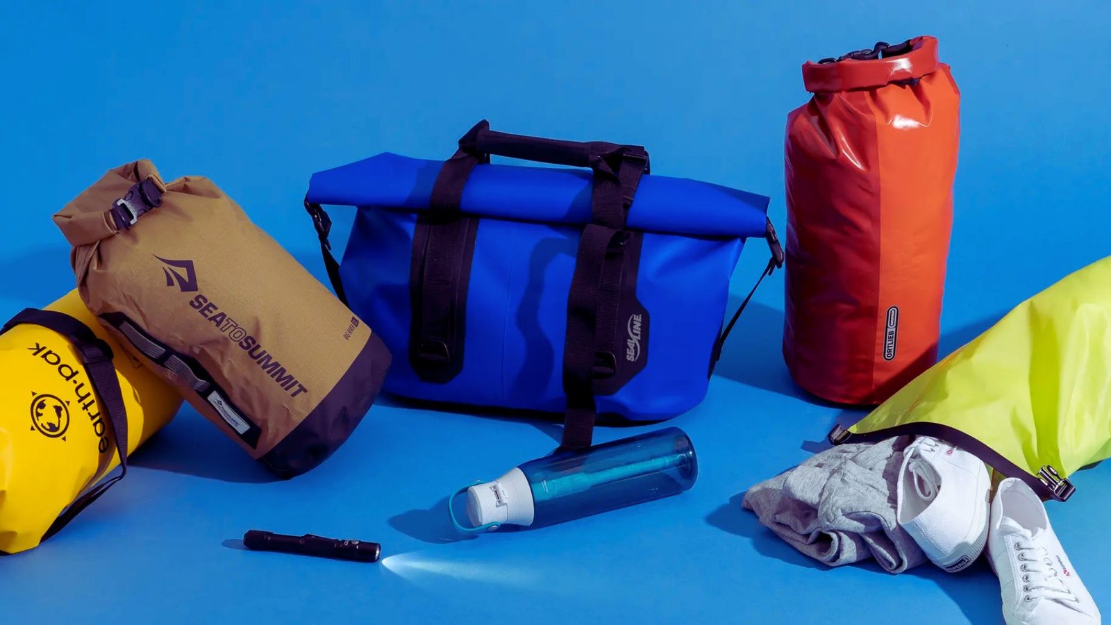 A collection of bags and assorted items placed on a blue surface, creating a vibrant and visually appealing scene.