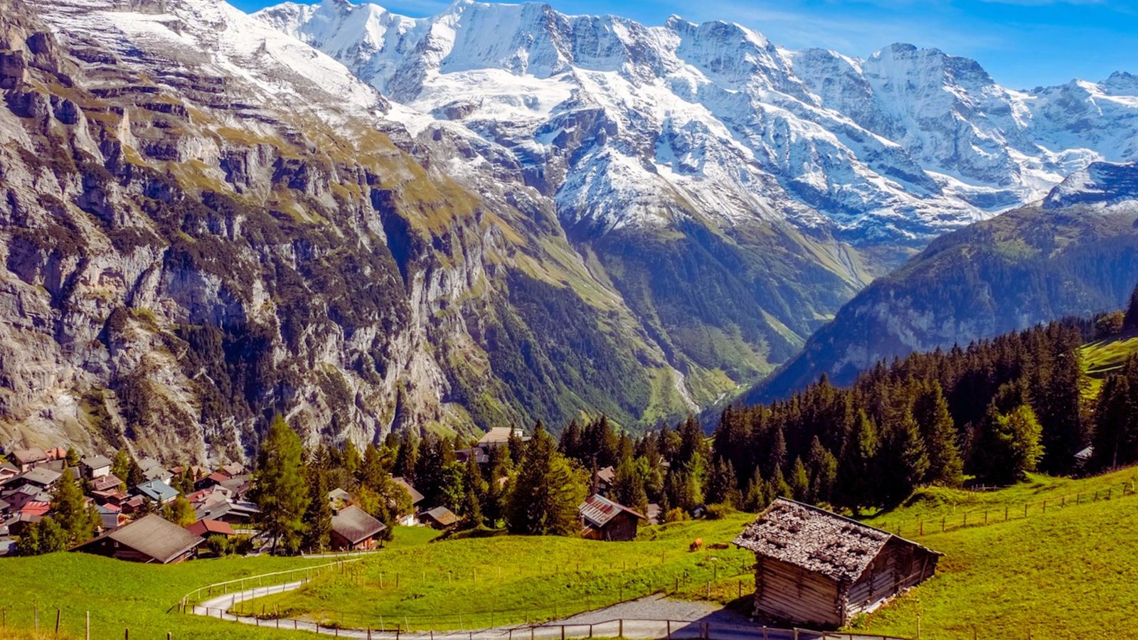  Majestic Swiss Alps with snow-capped peaks under a clear blue sky, showcasing the beauty of Switzerland's mountainous landscape.
