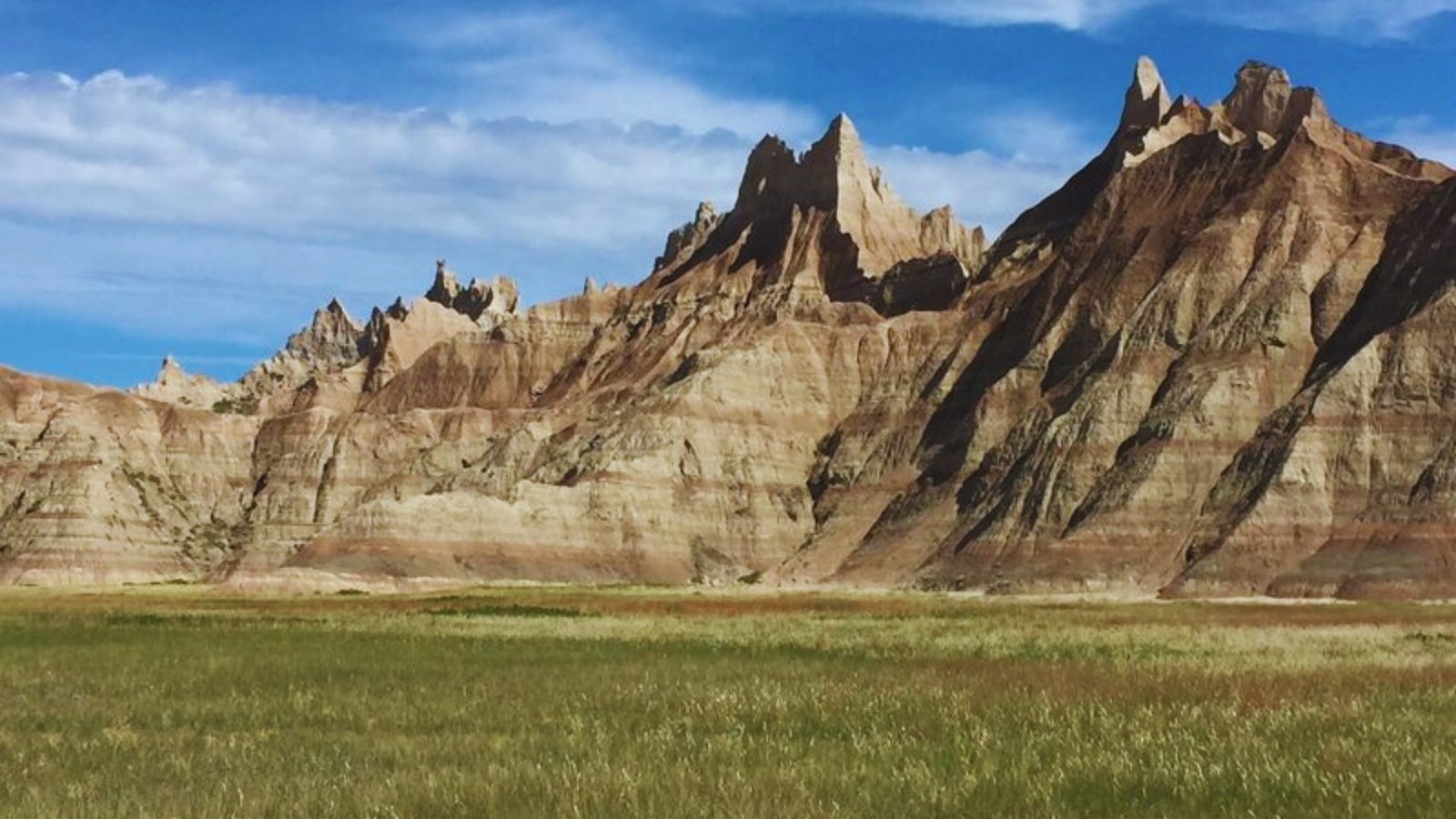  Expansive view of Badlands National Park in Wyoming, showcasing rugged terrain and unique rock formations under a clear sky.
