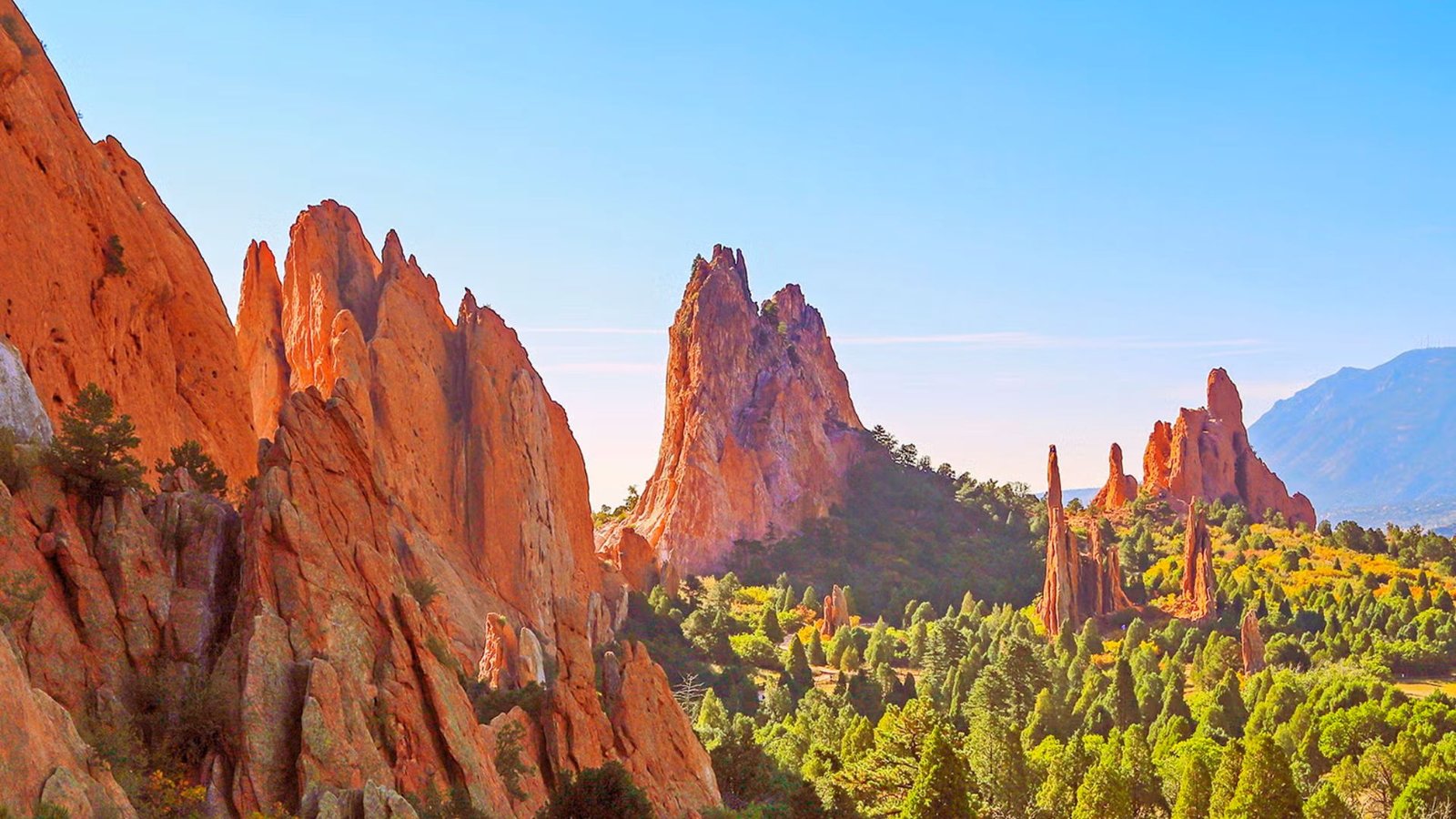 Scenic view of Garden of the Gods in Colorado, featuring striking red rock formations against a clear blue sky.