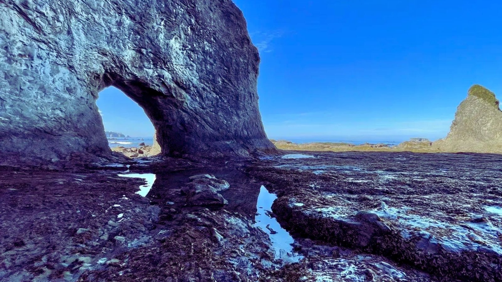 Image of a rock arch taken by Jimmy Kirk, highlighting the unique structure and textures of the stone formation.