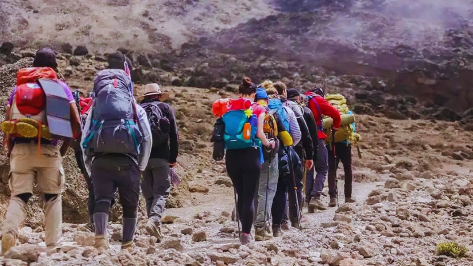  A group of hikers with backpacks traverses a rocky landscape, showcasing their adventurous spirit in nature.