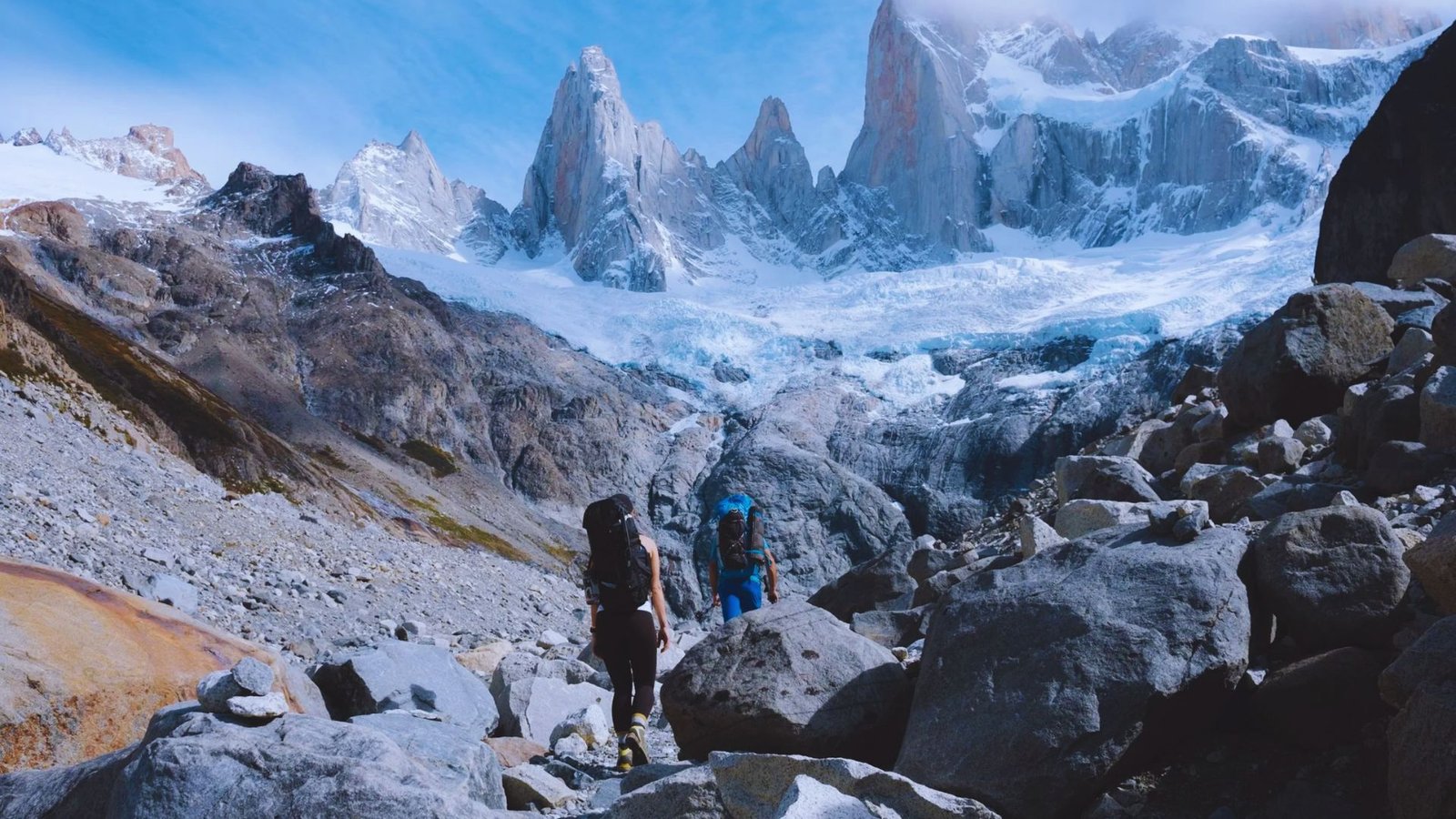 Hikers trekking through the stunning landscapes of Patagonia, surrounded by mountains and lush greenery.