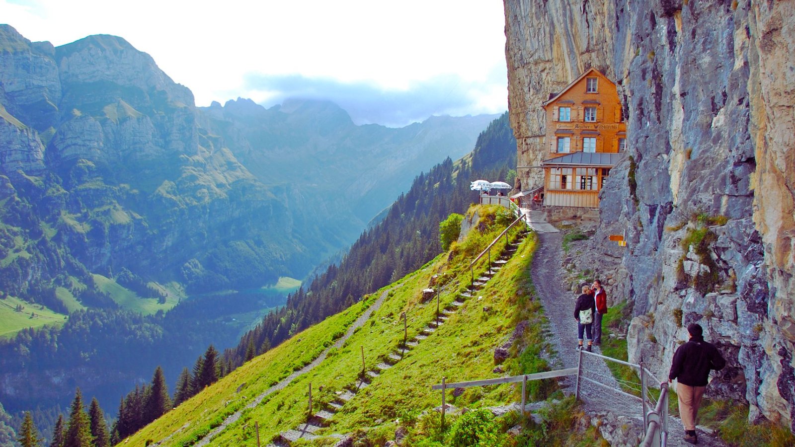  A house perched on a cliff, offering a stunning view of the expansive valley below.