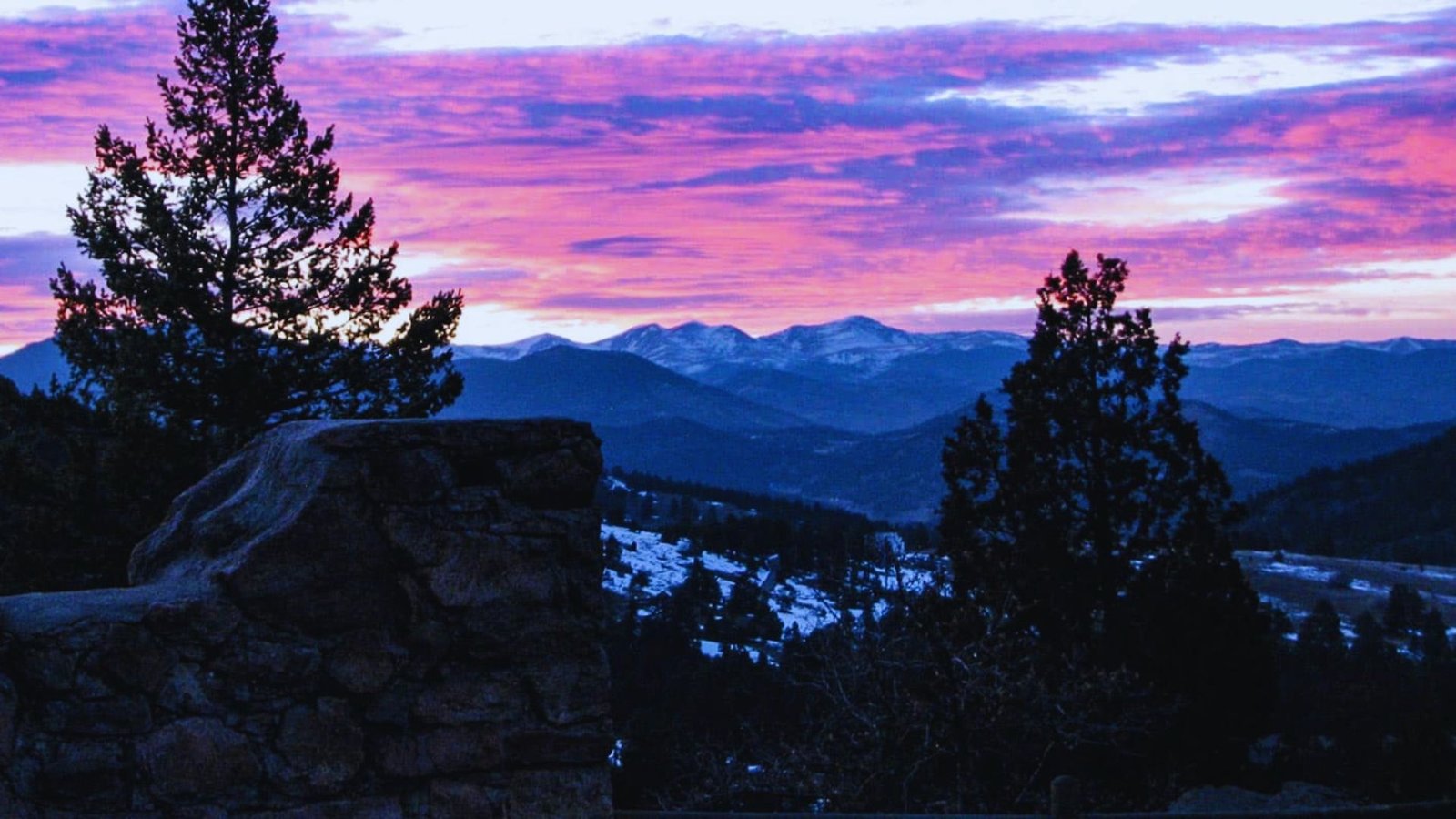 A scenic view of a purple sky above snow-covered mountains in the background.
