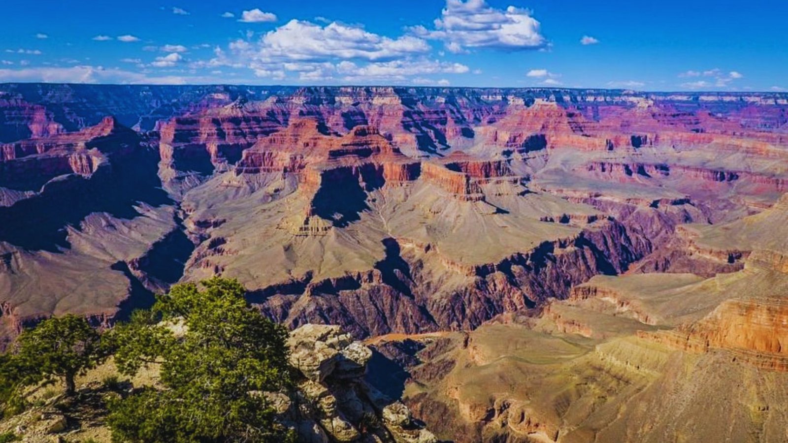 A panoramic view of the Grand Canyon, a renowned tourist destination in the United States, showcasing its vast landscapes.
