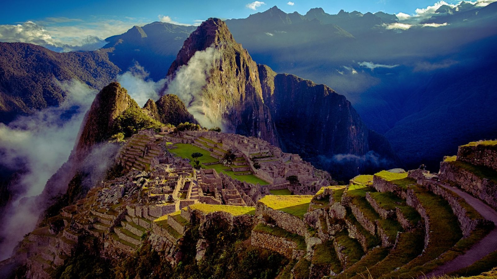  A panoramic view of Machu Picchu, showcasing the ancient Inca ruins set against a backdrop of lush green mountains.