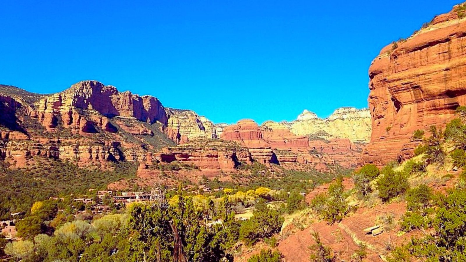 Red rock formations in Sedona, Arizona, showcasing vibrant colors and unique geological shapes against a clear blue sky.