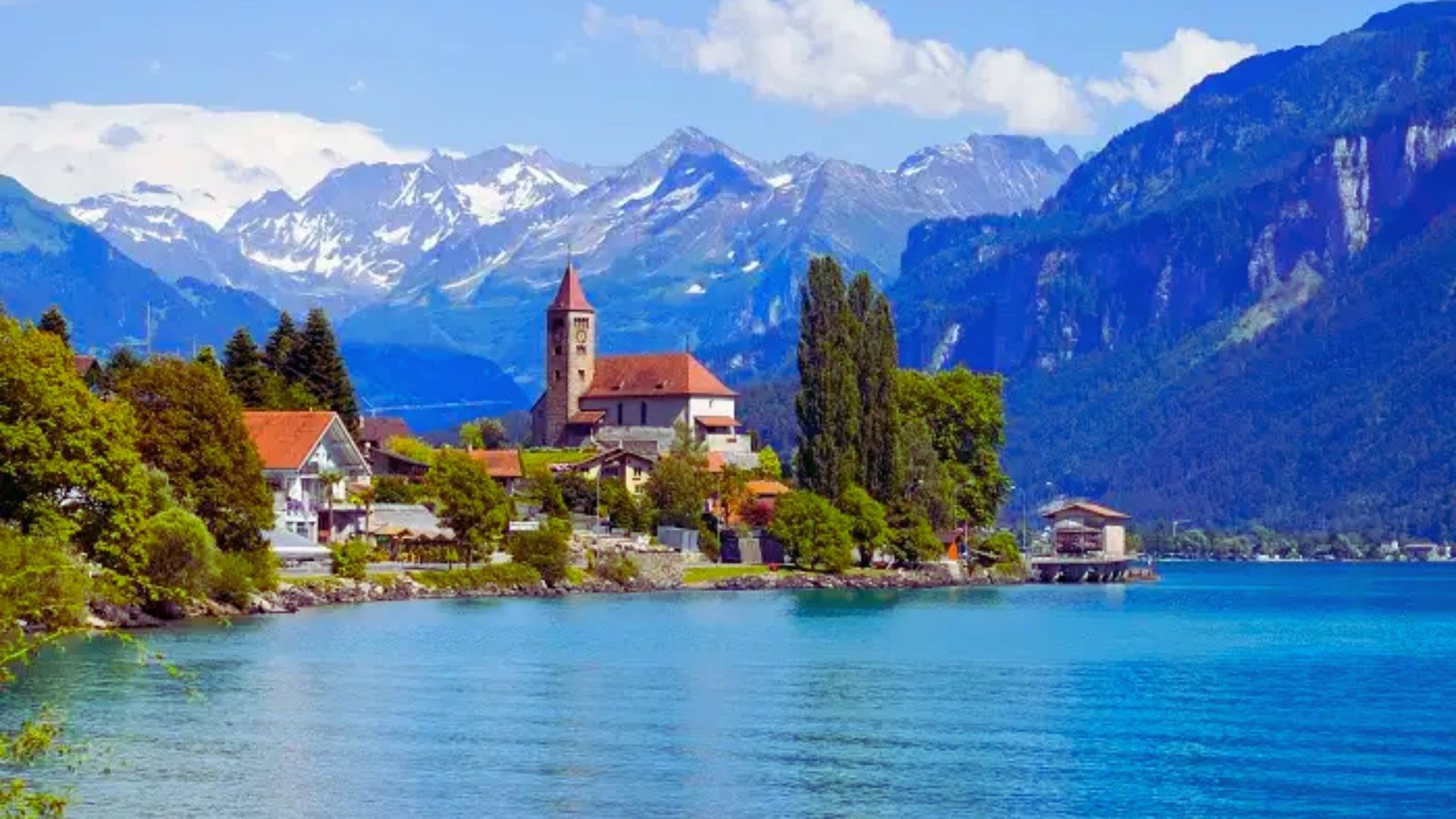 A serene lake surrounded by a small town, reflecting the beauty of nature and community life.