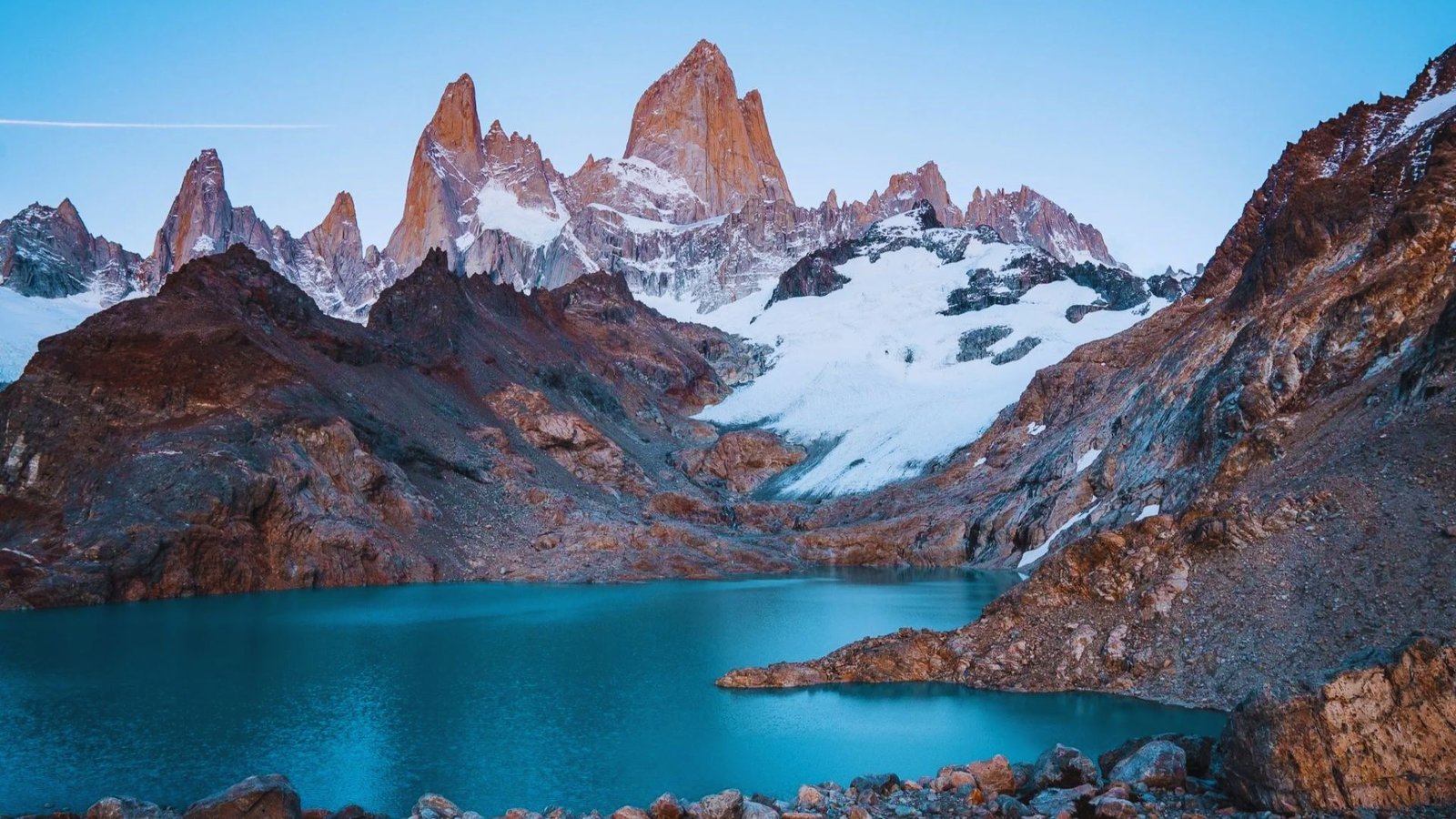 Sunrise over the stunning Patagonia landscape, showcasing mountains and valleys bathed in warm, golden light.