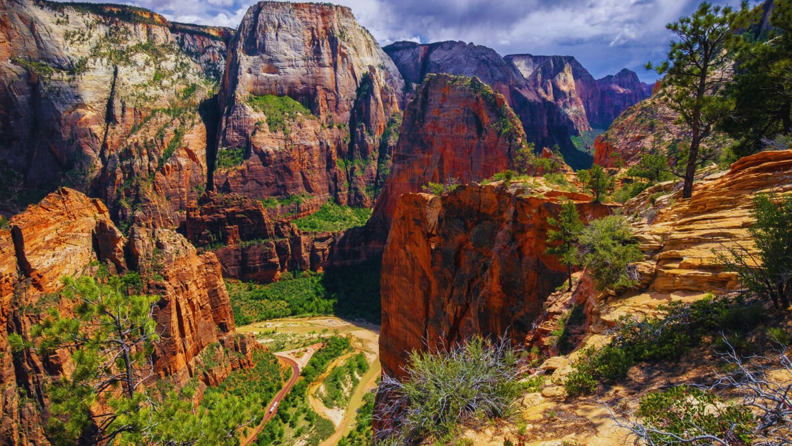 Zion Canyon in Zion National Park, Utah, showcasing towering red rock formations and lush greenery along the West Rim Trail.