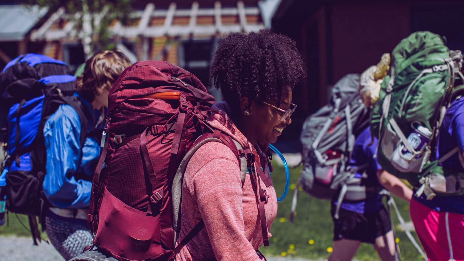 A group of people carrying backpacks walking together down a city street.
