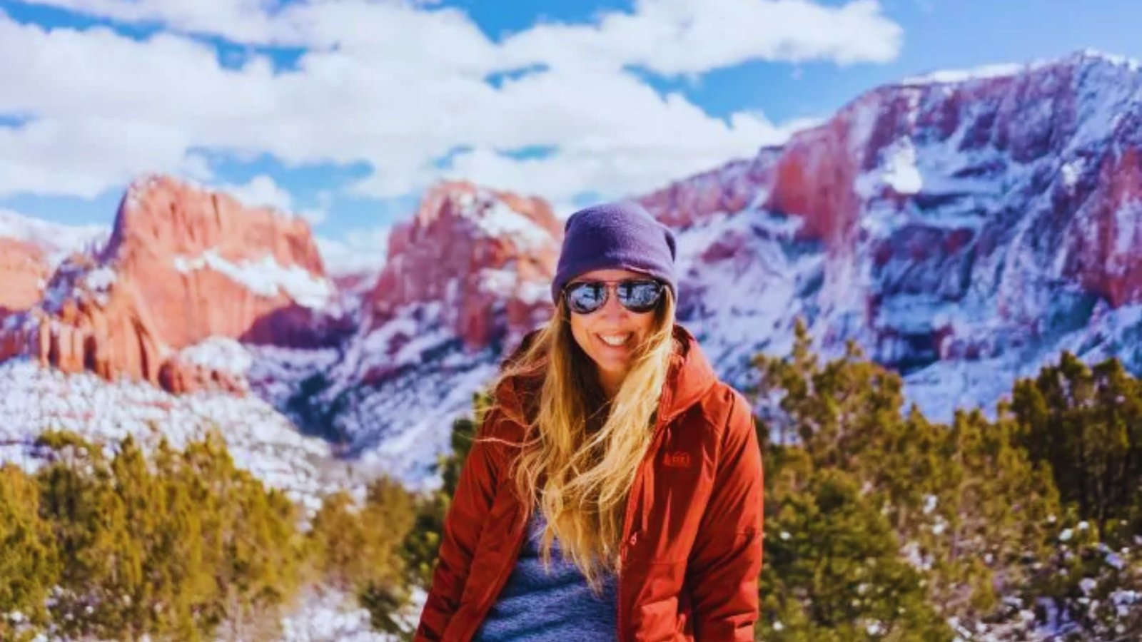 A woman wearing sunglasses and a red jacke
