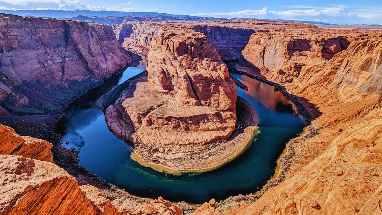 Scenic view of Horseshoe Bend, showcasing the dramatic curve of the Colorado River surrounded by towering canyon walls.