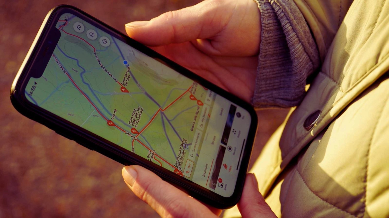 A person grasping a cell phone that shows a map, likely for finding directions or exploring an area.