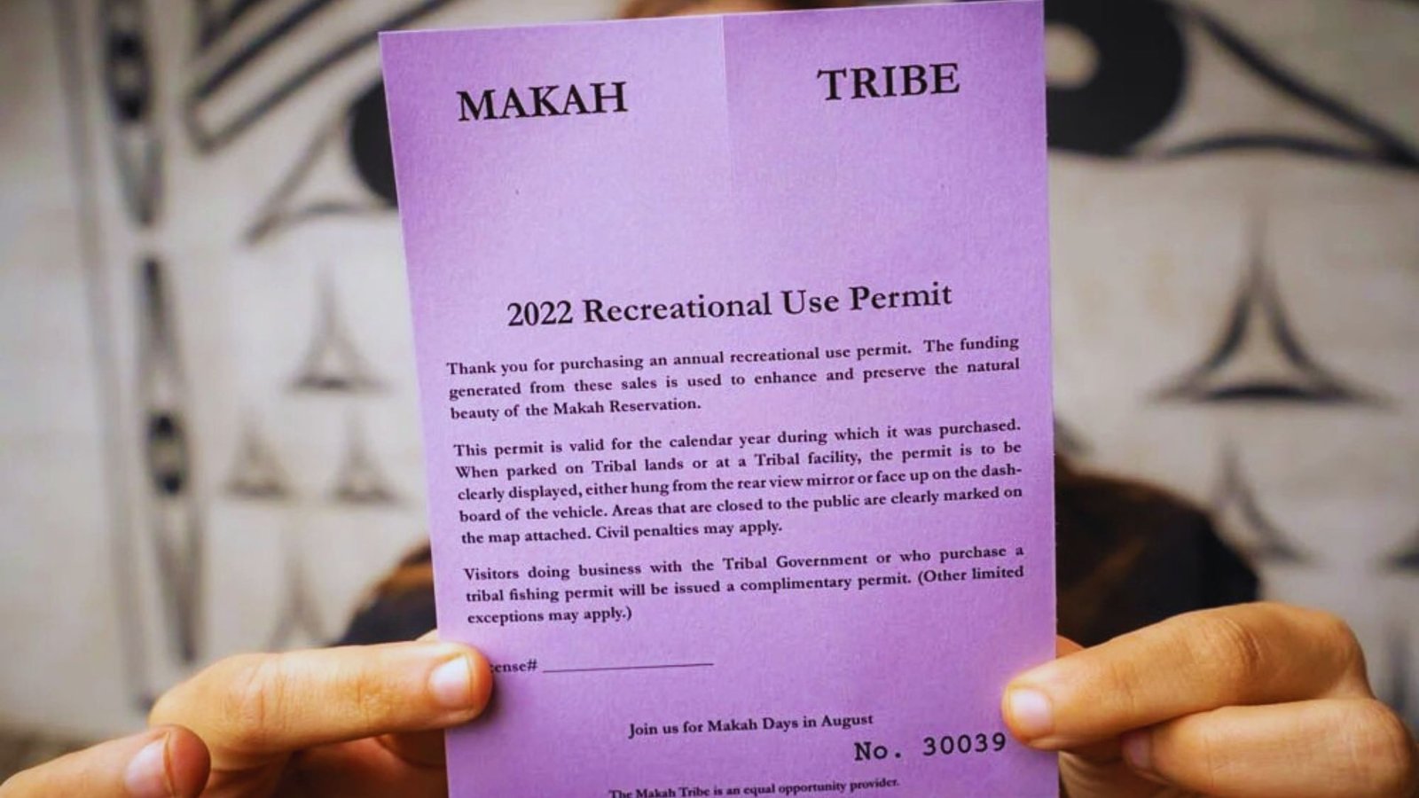 On the Shi Shi Beach Trail, an individual displays a card with a face graphic, showcasing their experience.
